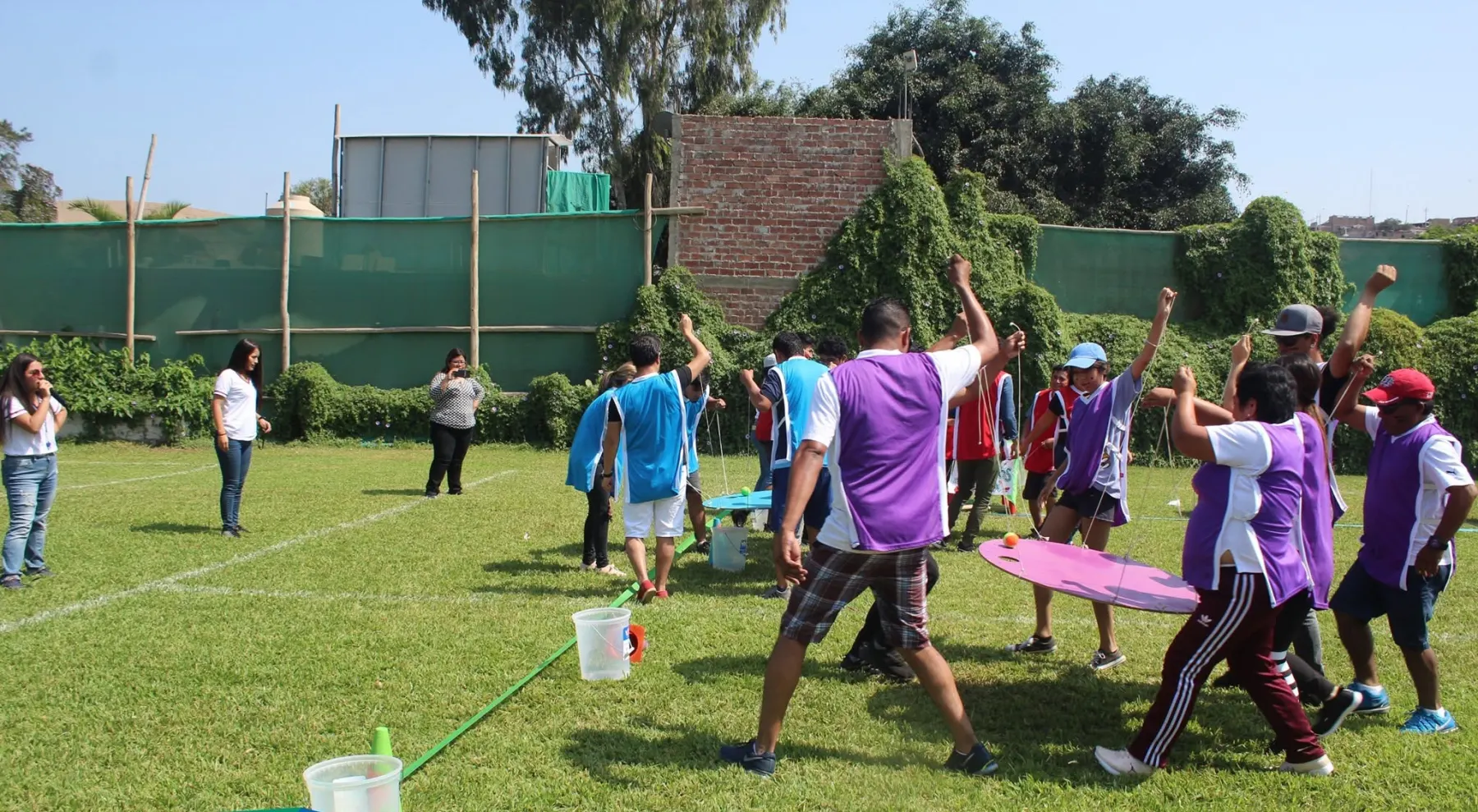 Equipos de una empresa compitiendo con petos de colores en una gymkana al aire libre