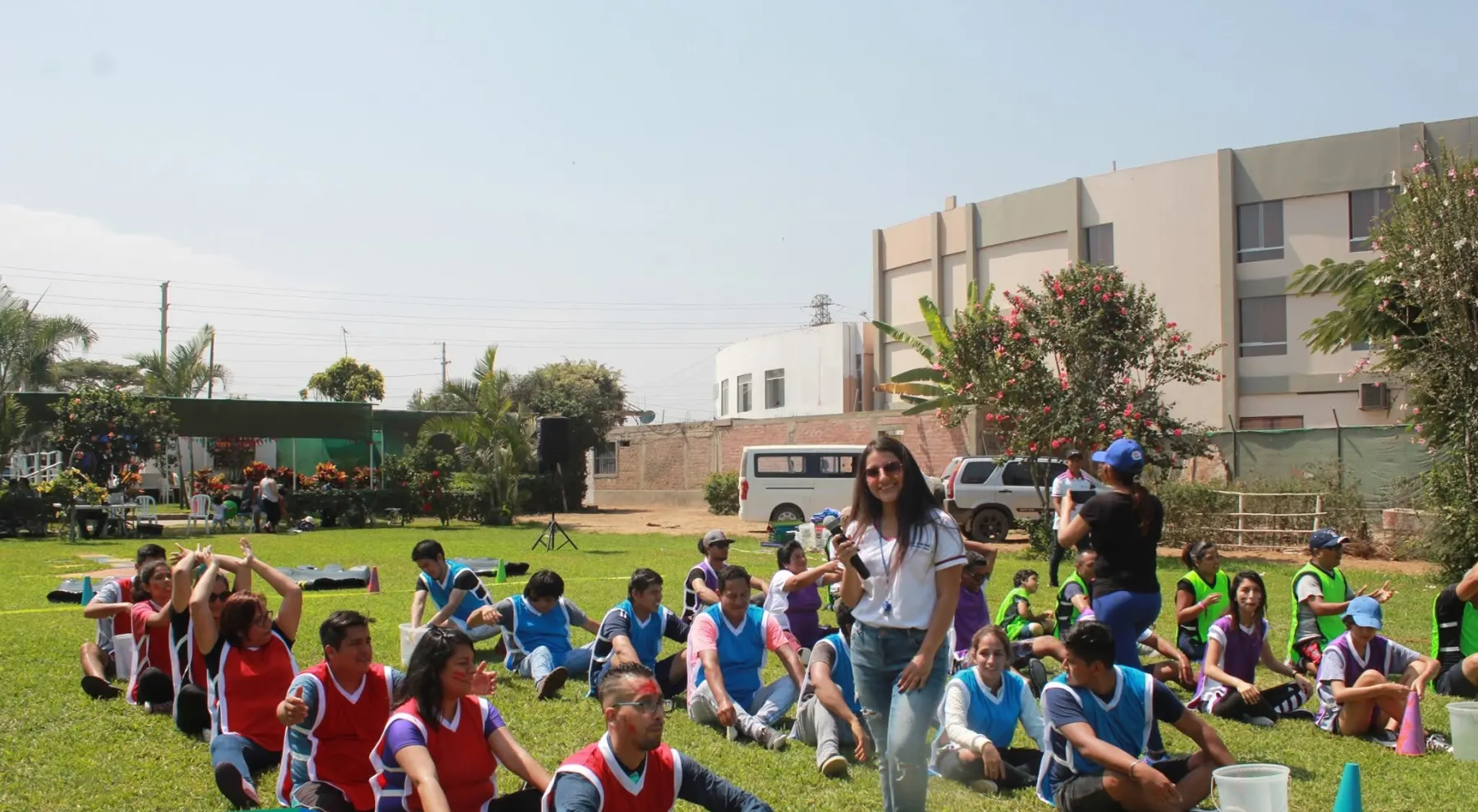 Un grupo grande de personas riendo durante una actividad compartida al aire libre