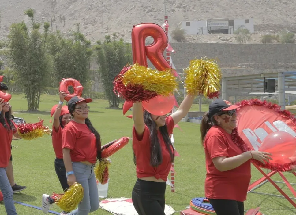 Una barra de una empresa anima con pompones y globos durante una jornada de integración al aire libre